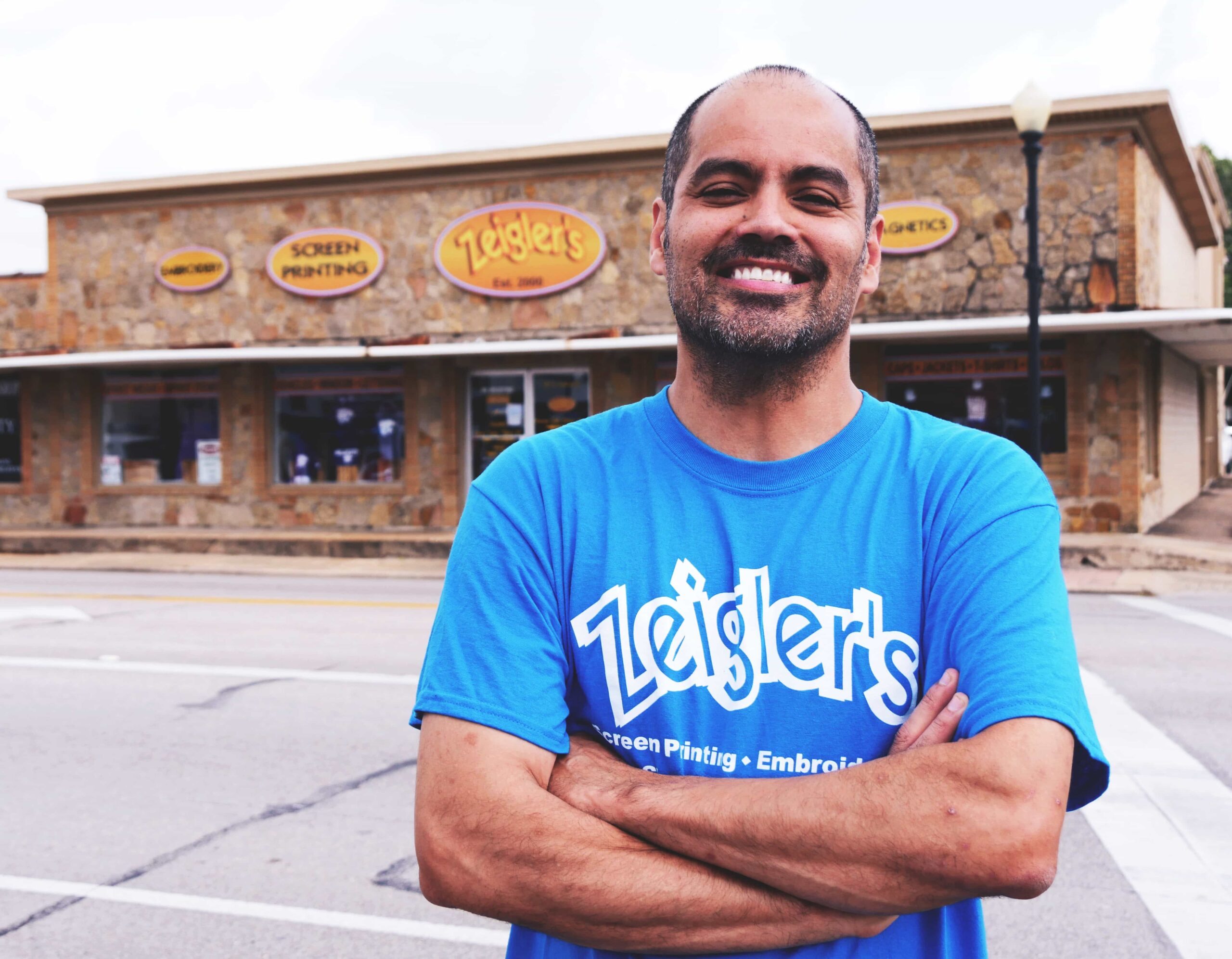 Owner of Zeigler’s Graphics standing outside the Angleton shop